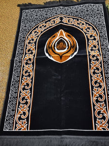 Black prayer mat with image of black stone